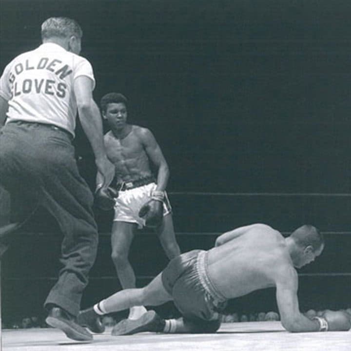 Muhammad Ali, arm raised, in a Golden Gloves ring